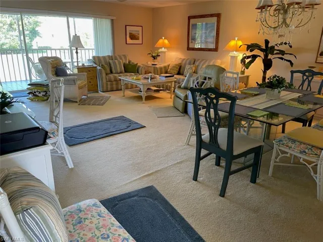 Dining area featuring light carpet and a chandelier