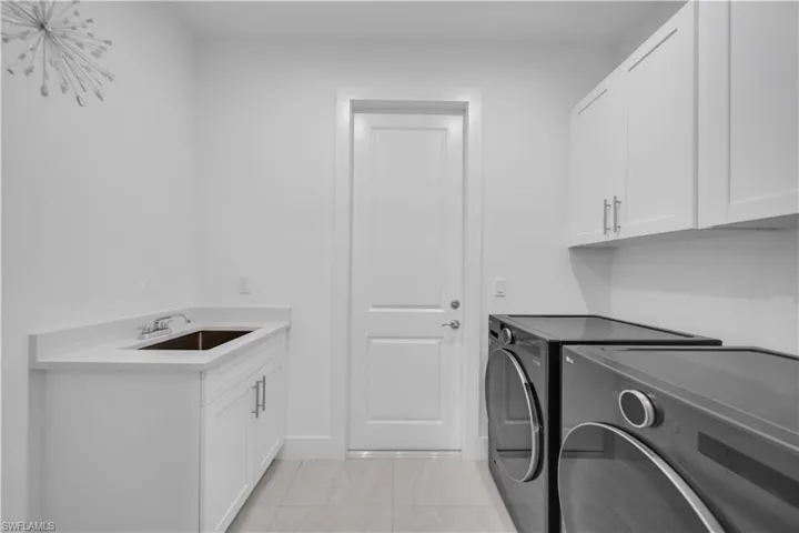 Laundry area featuring separate washer and dryer and cabinet space