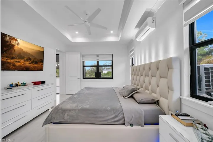 Bedroom featuring a wall unit AC, ceiling fan, and recessed lighting