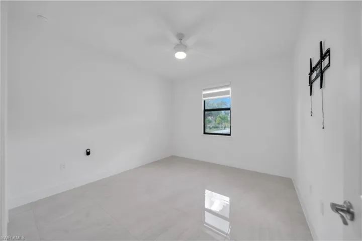 Empty room with baseboards and a ceiling fan