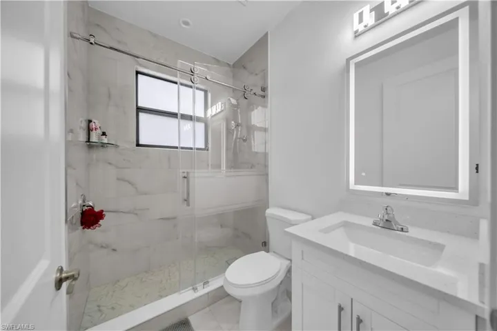 Full bathroom with vanity and a marble finish shower