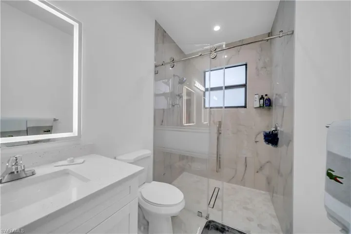 Full bath with vanity and a marble finish shower