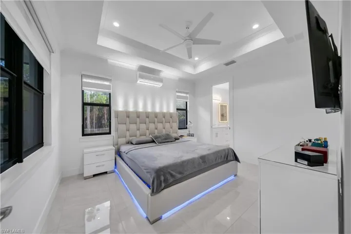 Bedroom with crown molding, ceiling fan, recessed lighting, ensuite bathroom, and an AC wall unit