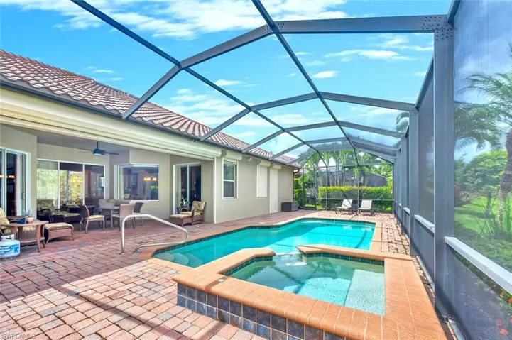 View of pool with a sunroom, a ceiling fan, a pool with connected hot tub, a patio, and a lanai