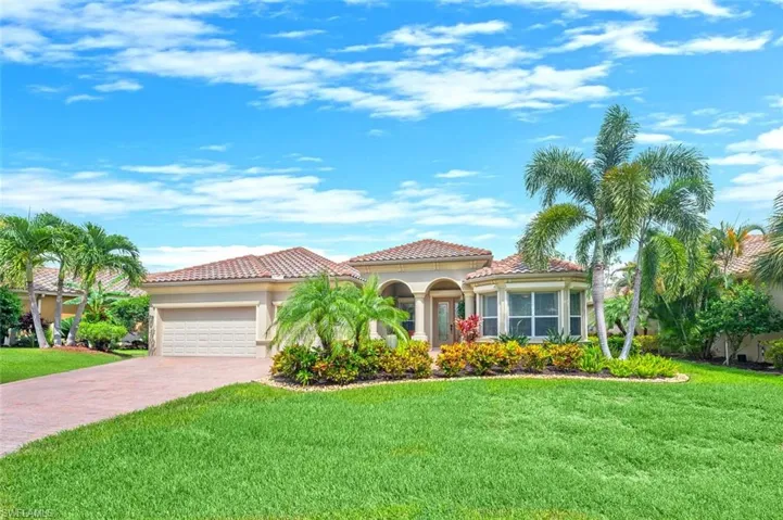 Mediterranean / spanish-style house featuring a front lawn, an attached garage, stucco siding, driveway, and a tile roof