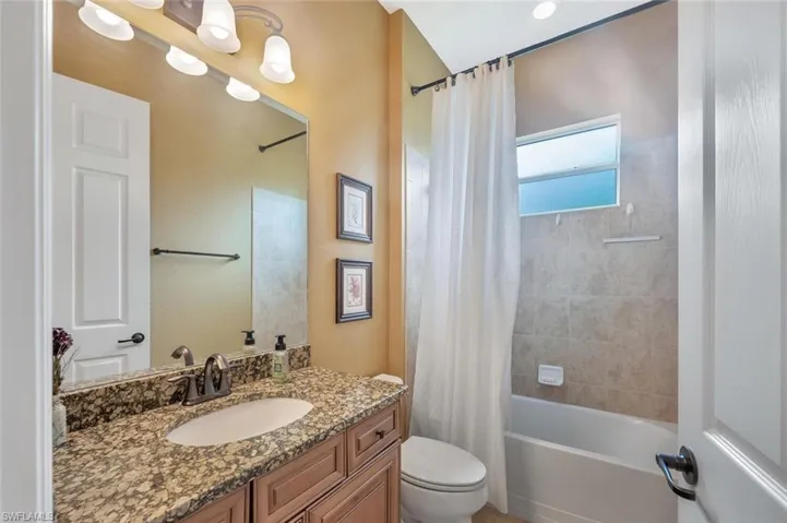 Full bathroom with shower / tub combo with curtain and vanity
