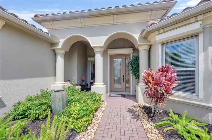 View of exterior entry featuring stucco siding and a tile roof
