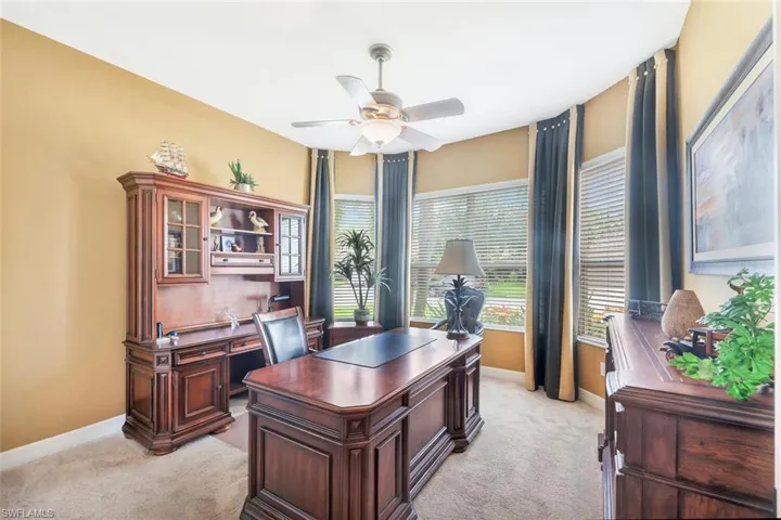 Office area featuring light carpet and a ceiling fan