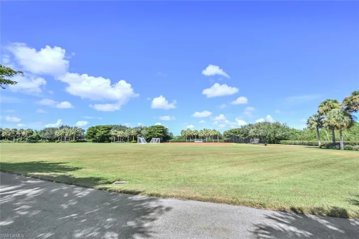View of community featuring a yard and view of wooded area