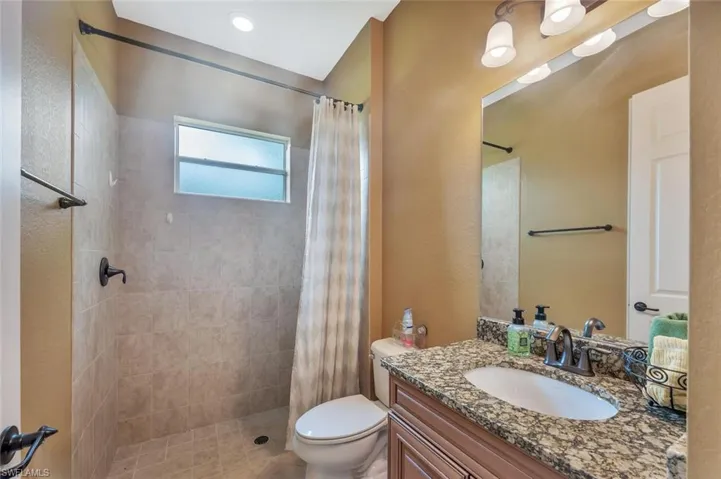 Bathroom featuring vanity, a shower stall, and a textured wall