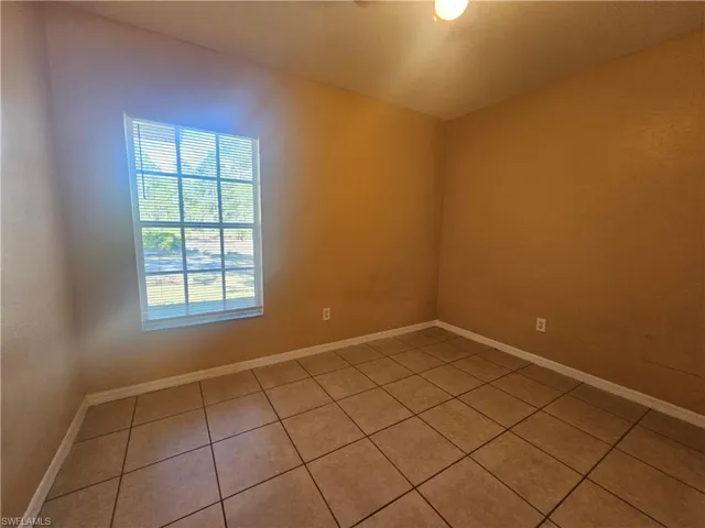 Spare room featuring baseboards and light tile patterned floors