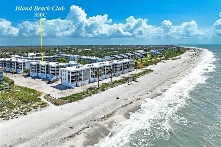 Island Beach Club 320C features modern coastal architecture with multi-story residential construction, direct beachfront positioning, and expansive sandy beach with Atlantic Ocean frontage
