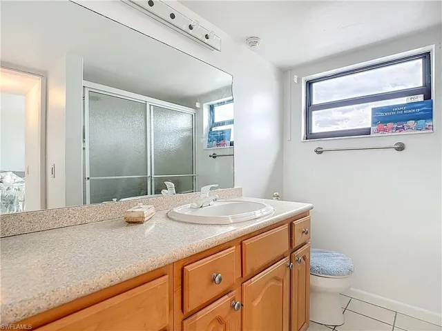 Full bath featuring light tile patterned floors, a shower stall, and vanity