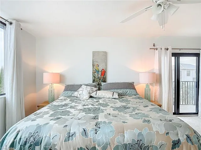 Bedroom featuring multiple windows, a ceiling fan, access to outside, and light colored carpet