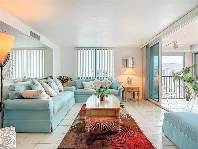 Living room with light tile patterned floors, floor to ceiling windows, and a textured ceiling