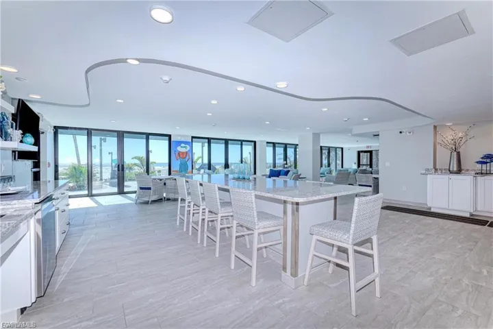 CLUBROOM Kitchen featuring light stone counters, floor to ceiling windows, open floor plan, white cabinets, and recessed lighting