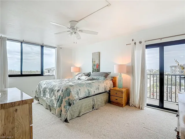 Bedroom with light colored carpet, access to exterior, and a ceiling fan