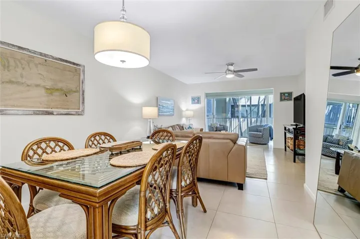 Dining room with ceiling fan, plenty of natural light, and light tile patterned flooring