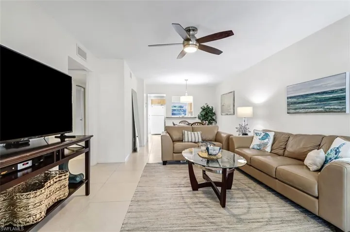 Living area featuring a ceiling fan and light tile patterned floors