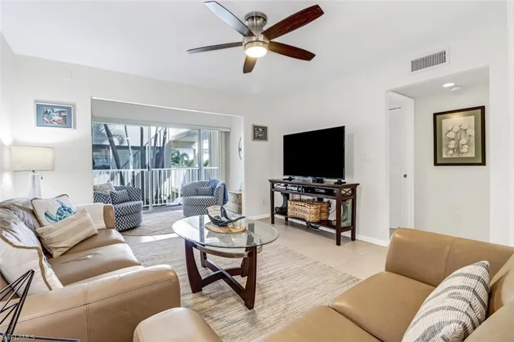 Living room with ceiling fan and light tile patterned floors