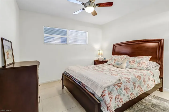 Bedroom with ceiling fan and light tile patterned flooring