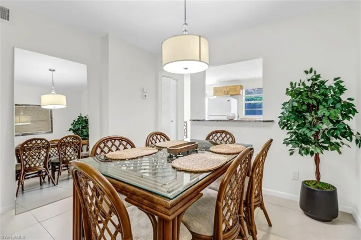 Dining area with light tile patterned floors and baseboards