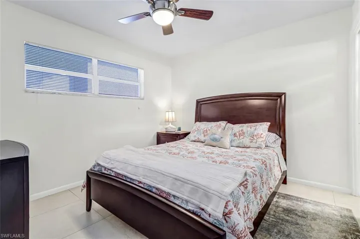 Tiled bedroom with baseboards and ceiling fan