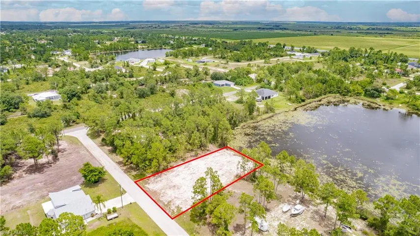 Aerial view of property and surrounding area with a large body of water and property parcel outlined