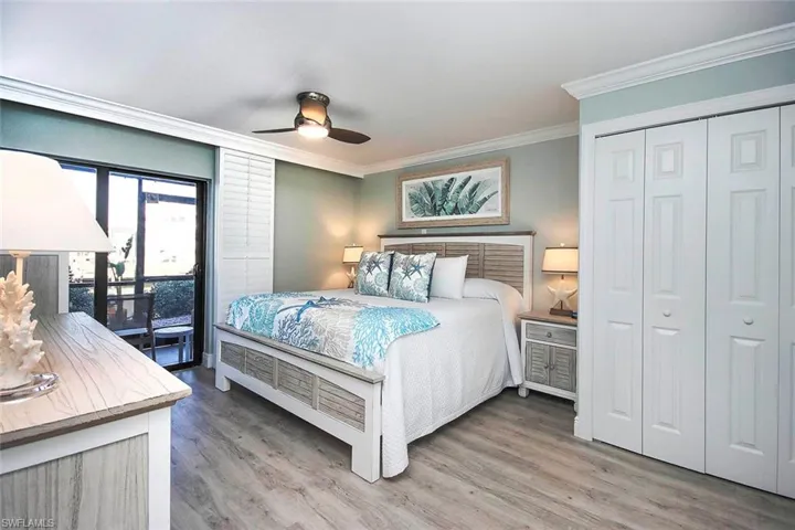Bedroom with access to exterior, ceiling fan, crown molding, wood-LVP flooring, and a closet