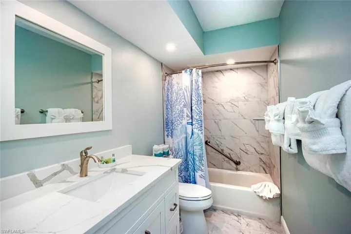 Full bathroom with vanity, toilet, and shower / bath combo with shower curtain