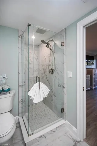 Bathroom featuring an enclosed shower and toilet