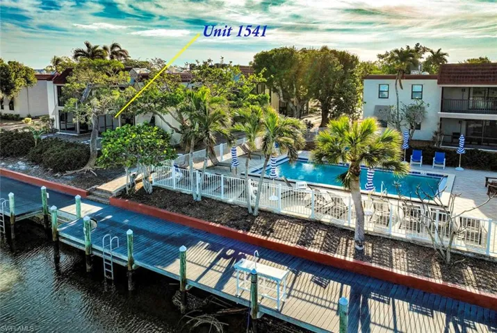 View of swimming pool with a canal view and a dock