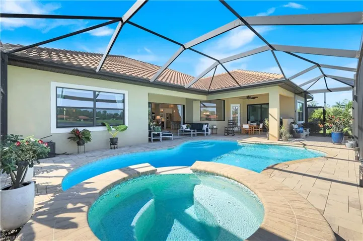 View of pool featuring a sunroom, a patio, a pool with connected hot tub, and a lanai