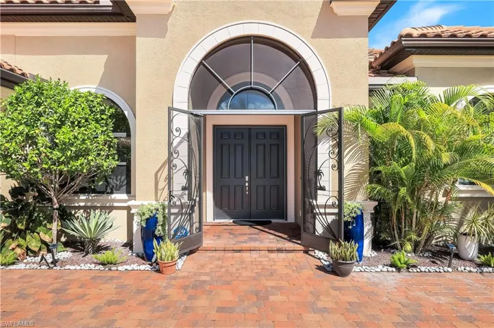 Entrance to property with stucco siding and a tiled roof