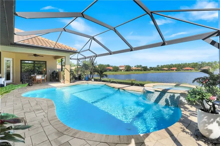 View of pool featuring panoramic screen for unobstructed water view, spa w/ waterfall.  Outdoor dining area plumbed for outdoor Kitchen.