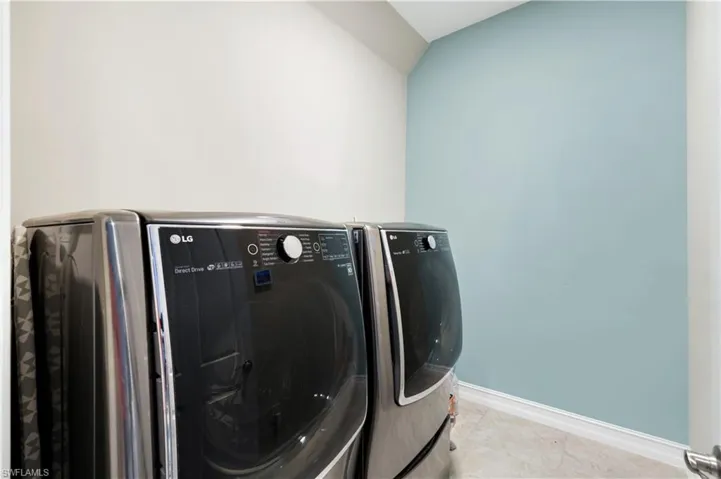 Laundry area with independent washer and dryer and tile patterned floors