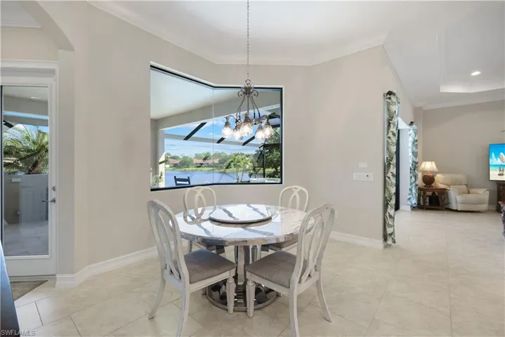 Dining area with ornamental molding, a chandelier, arched walkways, recessed lighting, and light tile patterned floors