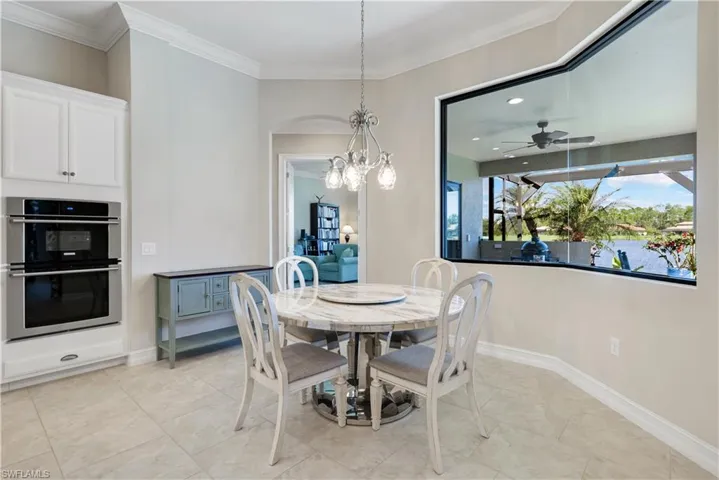 Dining room with a chandelier, light tile patterned floors, crown molding, a ceiling fan, and recessed lighting