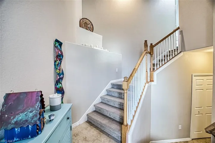 Stairs featuring tile patterned floors and a high ceiling