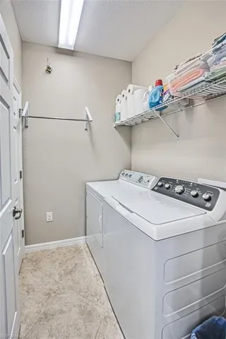Washroom featuring washer and dryer and a textured ceiling