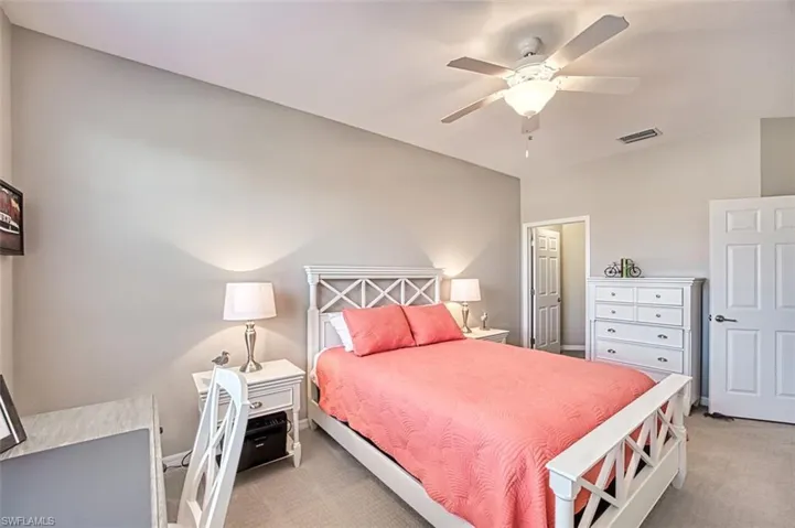 Carpeted bedroom featuring ceiling fan