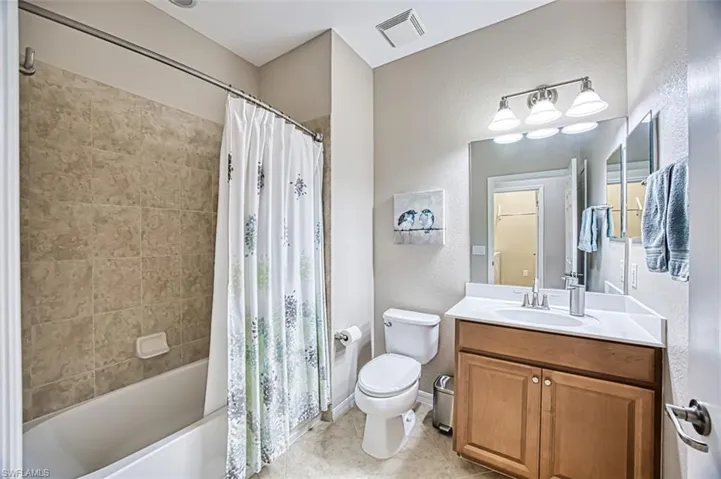Full bathroom with vanity, toilet, and shower / tub combo with curtain
