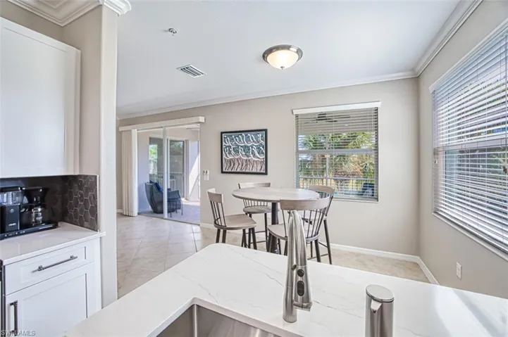 Tiled dining room featuring a healthy amount of sunlight and ornamental molding