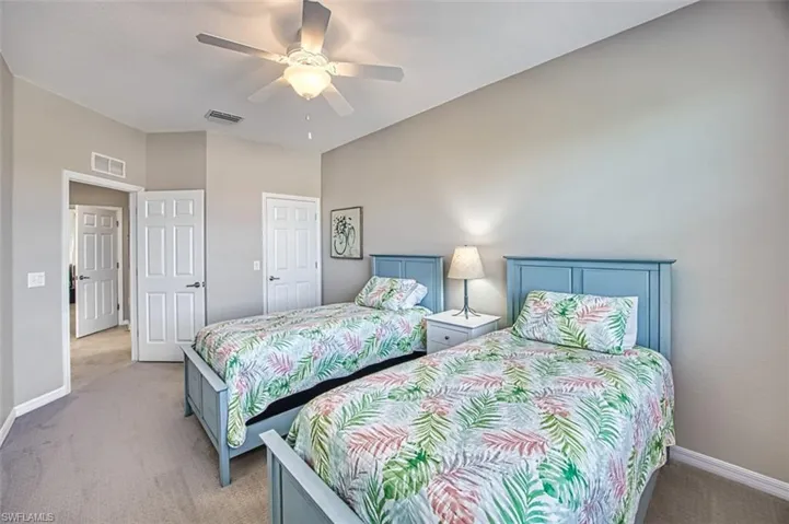 Carpeted bedroom featuring ceiling fan