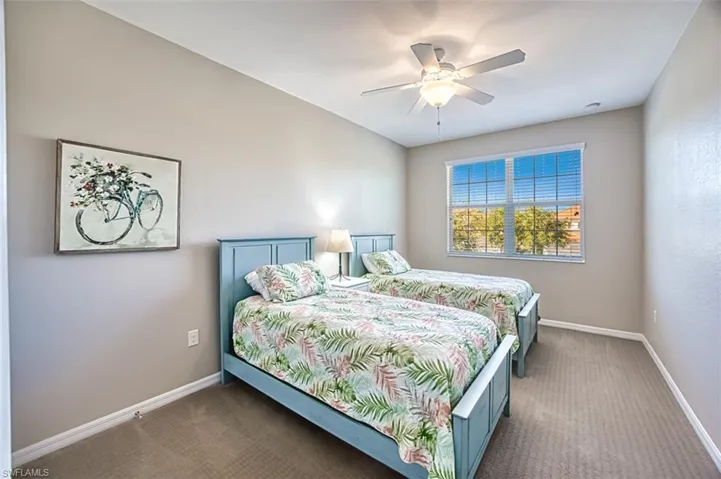 Carpeted bedroom featuring ceiling fan