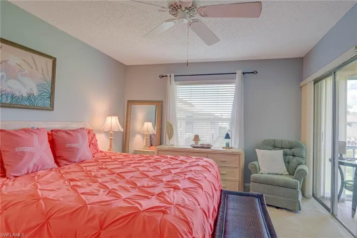 Bedroom with access to exterior, a textured ceiling, a ceiling fan, and carpet