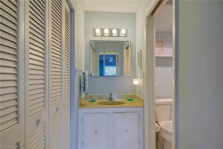 Bathroom featuring a closet, vanity, and a textured ceiling
