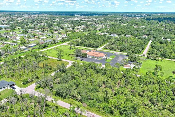 Aerial view of property's location featuring a tree filled landscape