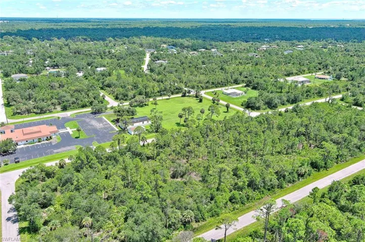 Aerial view of property and surrounding area with a forest