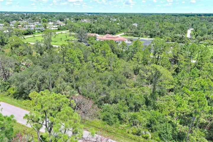 Aerial view of property's location featuring a heavily wooded area
